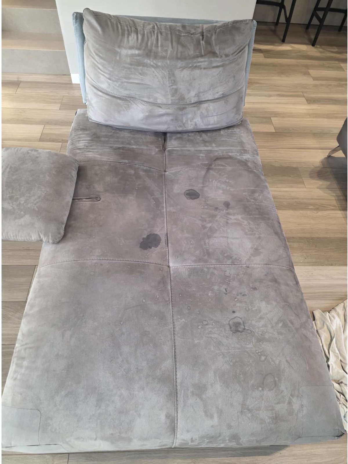 Divano in tessuto prima dell'intervento, con macchie evidenti